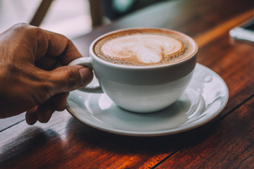 People are drinking a latte in a coffee shop.