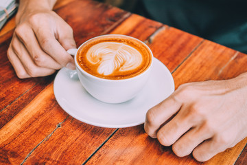 People are drinking a latte in a coffee shop.