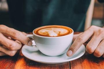 People are drinking a latte in a coffee shop.