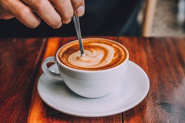 People are drinking a latte in a coffee shop.