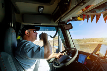 Male driver hands holding radio and steering wheel