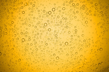 Water drops on yellow glass, Rain droplets on glass background.