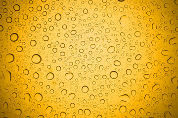Water drops on yellow glass, Rain droplets on glass background.