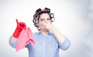 Young female in hair curlers emotionally pinches her nose with a hand from the stench.