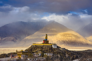 The Maitreya Buddha statue with Himalaya mountains in the background from Diskit Monastery or...