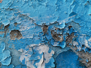 Blue background with cracked oil paint on plaster.