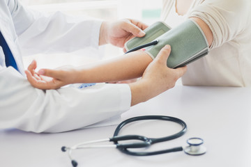 The doctor measures blood pressure to the patient