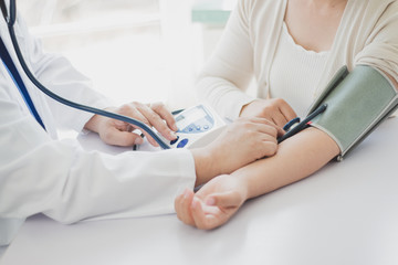 The doctor measures blood pressure to the patient - 263596289