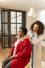 Woman with short hair cut sitting on chair while having massage