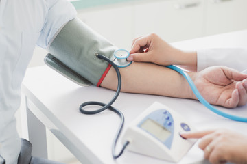 The doctor measures blood pressure to the patient