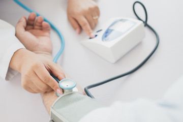 The doctor measures blood pressure to the patient