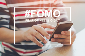 FOMO, fear of missing out concept. Close-up image of male hands using mobile smartphone