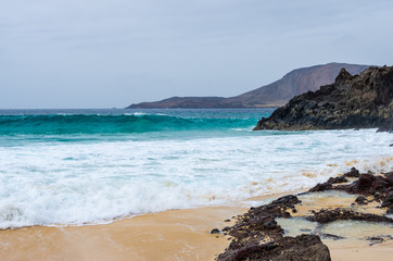 Waves crashing on the rocks on the beach of Playa de las Conchas