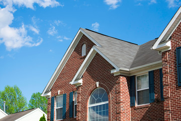 Residential Home with roofing gutters windows and blue sky