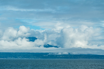island over sea on an overcast day surrounded by thick cloud