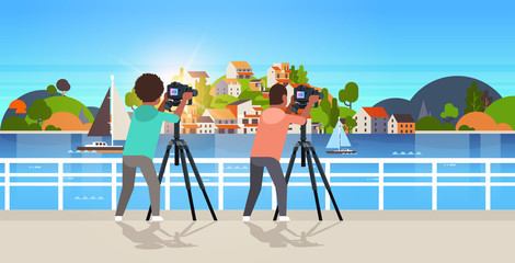 travel photographers taking nature picture of mountain city island african american guys using dslr camera on tripod landscape background horizontal