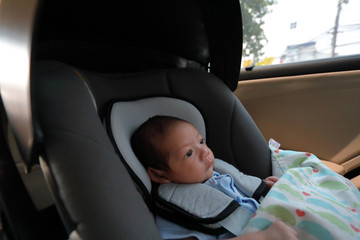 cute newborn baby sitting in car seat safety belt lock protection drive road trip