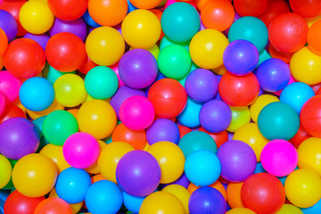 Fototapeta na wymiar Many colorful plastic balls in pool of game room. indoors playground