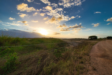 Fototapeta na wymiar sunset over a field on a path by the Alva beach 
