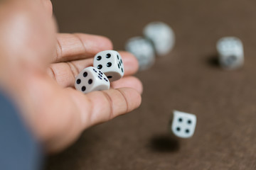 Man hand roll dice on board