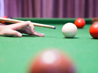 Girl hand on green table playing pool.