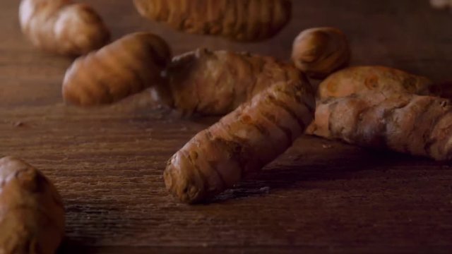 Fresh whole Turmeric root in slow motion
