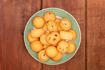 Danish butter cookies, shot from the top on a dark rustic wooden background with a place for text