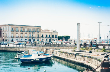 Obraz premium View of old street, facades of ancient buildings and sail boats in seafront of Ortygia (Ortigia) Island, Syracuse, Sicily, Italy.