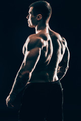 Fototapeta na wymiar rear view.handsome male bodybuilder .isolated on black