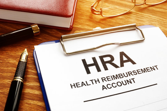 Health Reimbursement Account HRA with clipboard on desk.