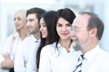 Close-up portrait of executive business people standing in a row at office and looking at the camera.