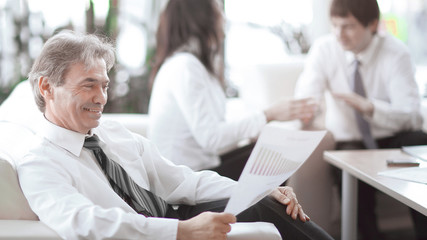 Fototapeta na wymiar businessman pondering a document sitting in a modern office
