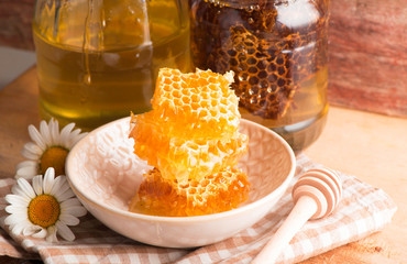 Fresh honeycombs in bowl on wooden background. closeup