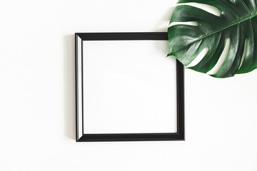 Summer composition. Tropical palm leaves, black photo frame on white background. Summer, nature...