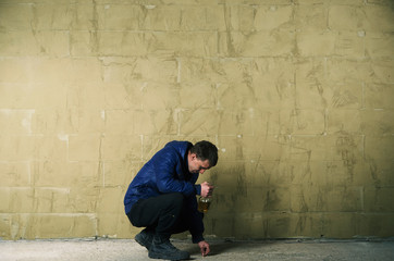 A disheveled man with alcohol in his hand.