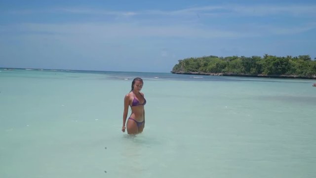 Slow Motion: Young Woman in Bikini Thigh-Deep in Blue Ocean Water in El Limon, Dominican Republic