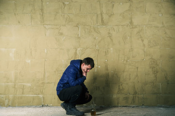 A disheveled man with alcohol in his hand.