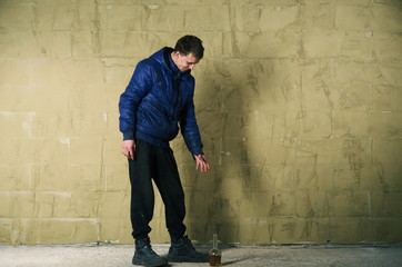 A disheveled man with alcohol in his hand.