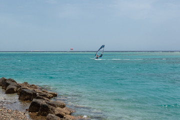 Naklejka premium windsurfing, windserfer young man on a windsurf on sea water 