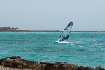 windsurfing, windserfer young man on a windsurf on sea water 