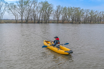 Kayak fishing at lake. Fisherwoman on inflatable boat with fishing tackle.