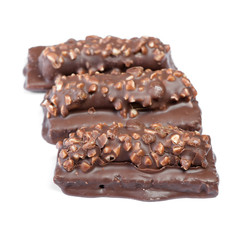 Small chocolate covered cakes with crushed nuts