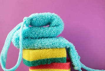 colored washcloths stacked on a trendy purple background, a place for advertising or text