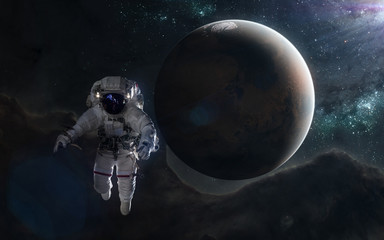 Astronaut and red planet in blue rays. Mars, Solar System. Science fiction art. Elements of the image were furnished by NASA
