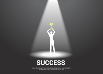 Silhouette of businessman with golden trophy in spotlight. business concept of winner and champion
