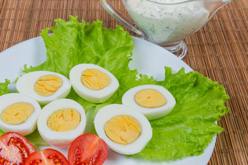 Halves of boiled chicken eggs with vegetables close-up