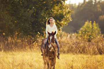 Young girl goes sorrel horse riding