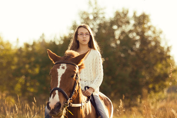 Fototapeta premium Young girl with sorrel horse in field
