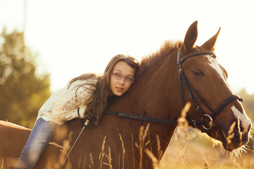 Young girl with sorrel horse in field