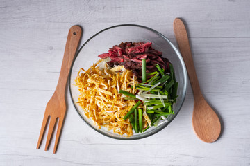 Asian food dish salad with meat and fried in wok vegetables. White background, top flat view.